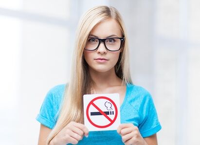 Girl holding a no smoking sign in the entrance